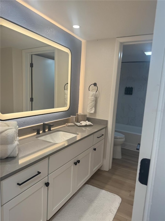 bathroom with vanity, hardwood / wood-style floors, toilet, and walk in shower