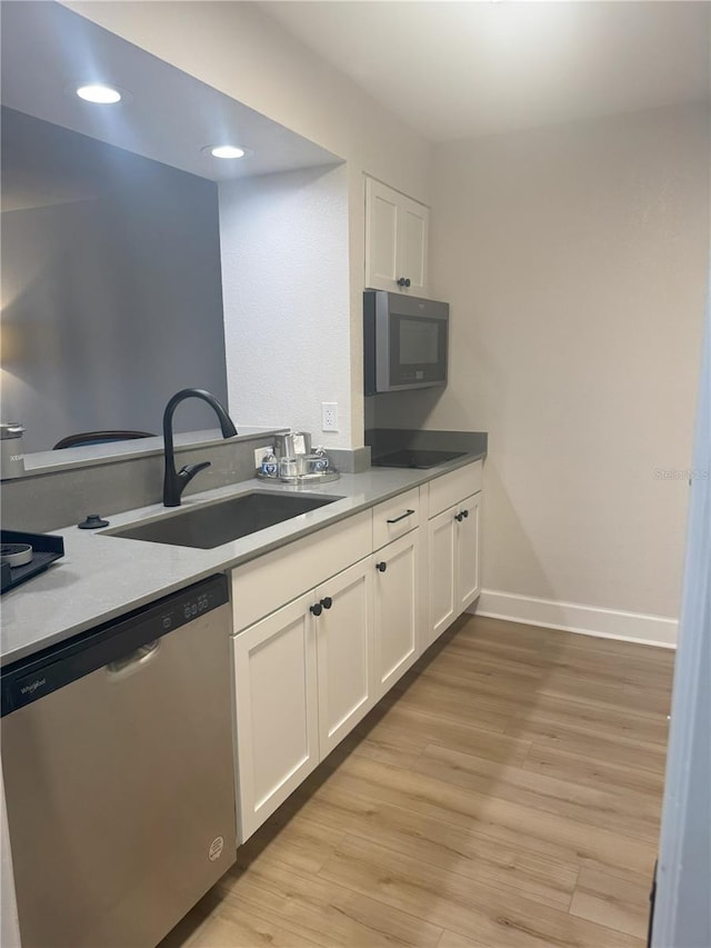 kitchen with white cabinetry, stainless steel appliances, sink, and light wood-type flooring