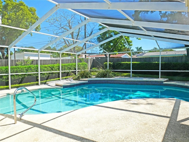 view of swimming pool featuring a patio and glass enclosure