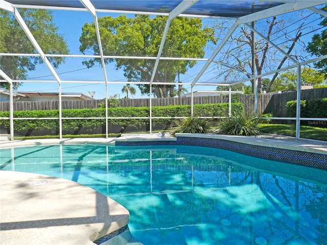 view of swimming pool with a patio and glass enclosure