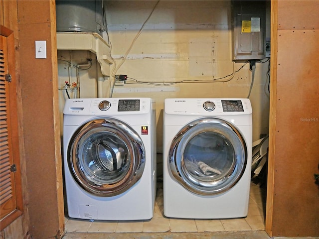 washroom featuring electric panel, washing machine and dryer, and light tile patterned floors