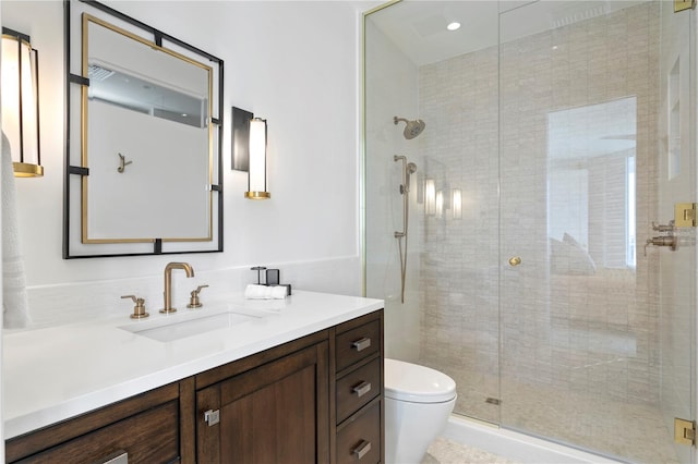 bathroom with vanity, toilet, and a shower with shower door