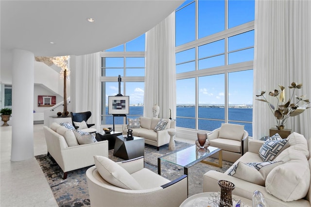 living room with a high ceiling and a water view