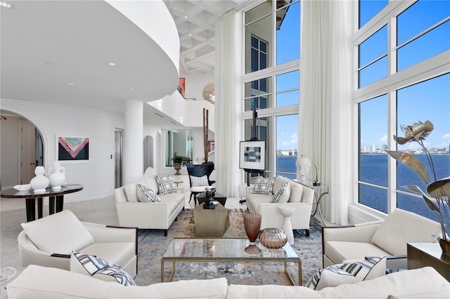 living room featuring a water view and a high ceiling