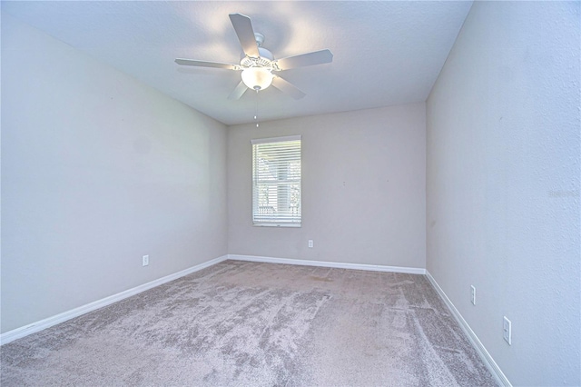 unfurnished room with ceiling fan and carpet