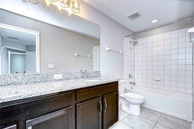 full bathroom with tiled shower / bath, vanity, toilet, and tile patterned floors