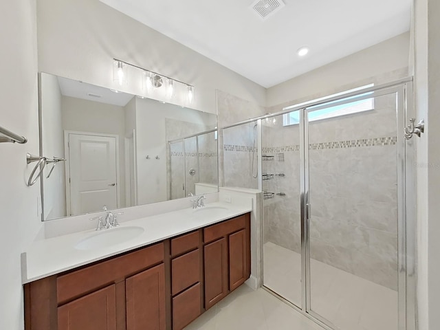 bathroom with tile patterned flooring, vanity, and a shower with door