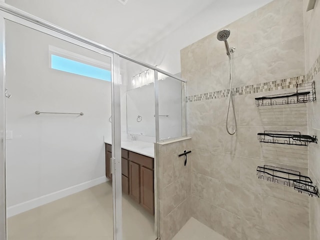 bathroom featuring tiled shower and vanity