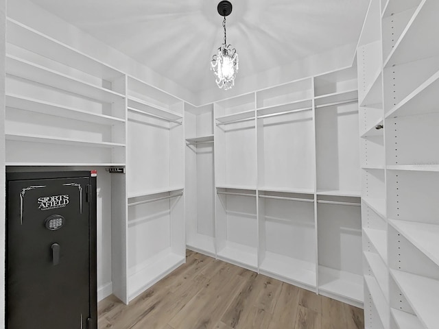 walk in closet with light hardwood / wood-style floors