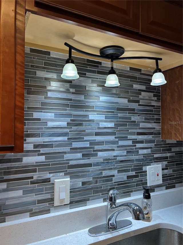 room details with sink, decorative backsplash, and decorative light fixtures