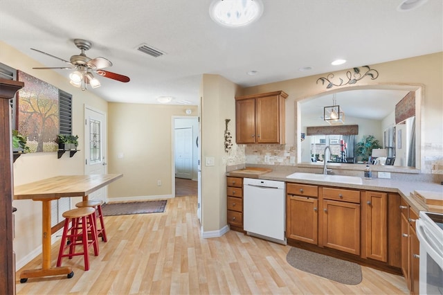 kitchen with hanging light fixtures, ceiling fan, light hardwood / wood-style floors, sink, and white appliances