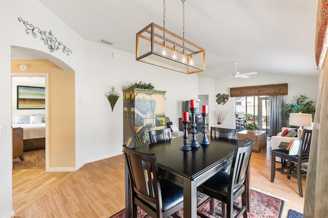 dining area with vaulted ceiling, hardwood / wood-style flooring, and ceiling fan