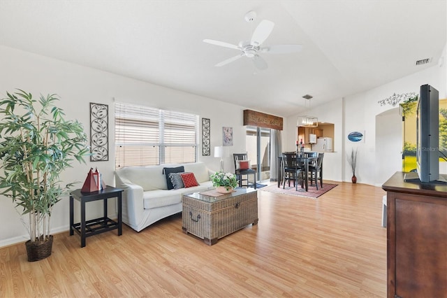 living room featuring light hardwood / wood-style floors, vaulted ceiling, and ceiling fan