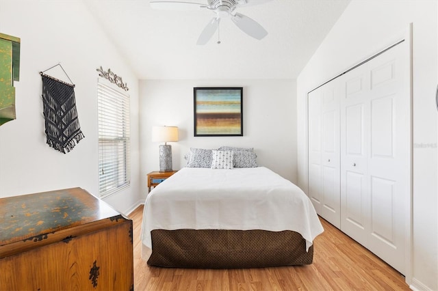 bedroom featuring light hardwood / wood-style flooring, a closet, vaulted ceiling, and ceiling fan