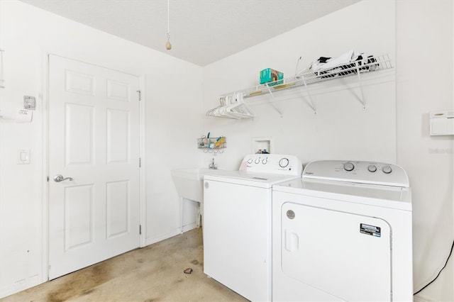 washroom with a textured ceiling and washing machine and dryer