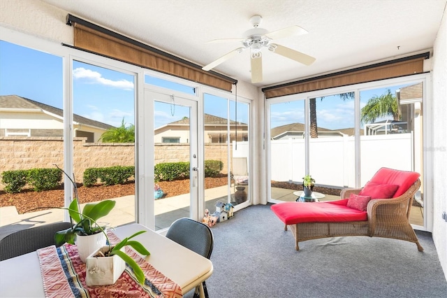 sunroom featuring ceiling fan and plenty of natural light