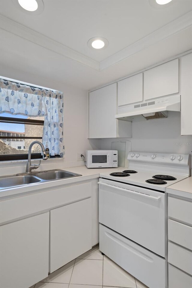 2571 Cyprus Dr Unit 1-202, Palm Harbor, FL 34684 - kitchen featuring white appliances, under cabinet range hood, a sink, white cabinets, and light countertops