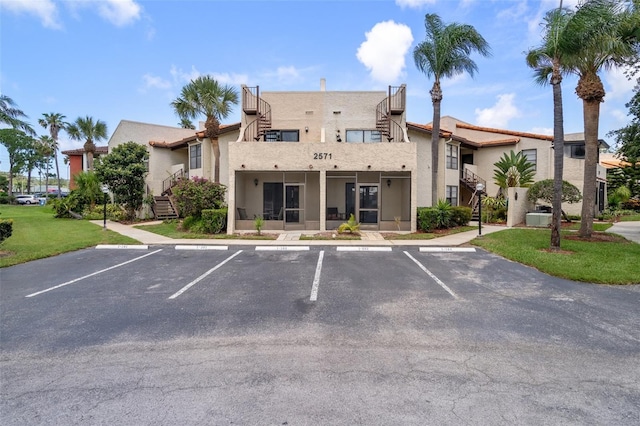 2571 Cyprus Dr Unit 1-202, Palm Harbor, FL 34684 - view of property featuring stairway and uncovered parking