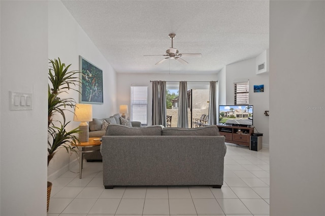 2571 Cyprus Dr Unit 1-202, Palm Harbor, FL 34684 - living area featuring ceiling fan, a textured ceiling, light tile patterned floors, and baseboards