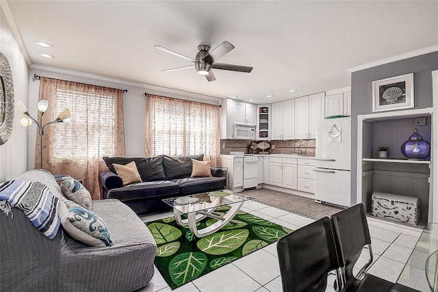 tiled living room featuring crown molding, sink, and ceiling fan