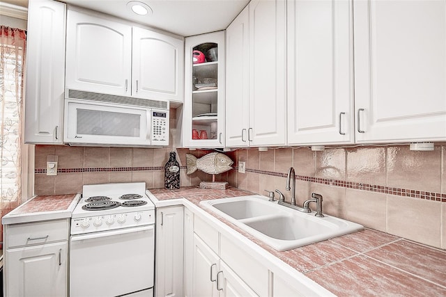 kitchen with sink, white cabinetry, decorative backsplash, and white appliances