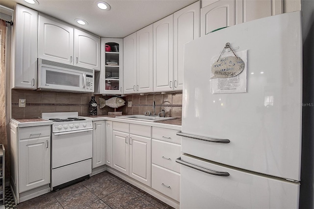 kitchen with white appliances, tasteful backsplash, white cabinetry, and dark tile patterned flooring