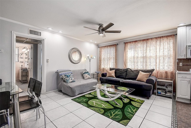 tiled living room with ornamental molding and ceiling fan