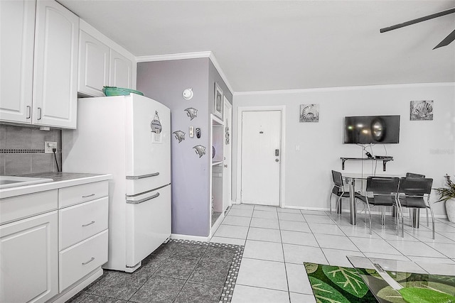 kitchen featuring ceiling fan, light tile patterned floors, white cabinetry, ornamental molding, and white refrigerator