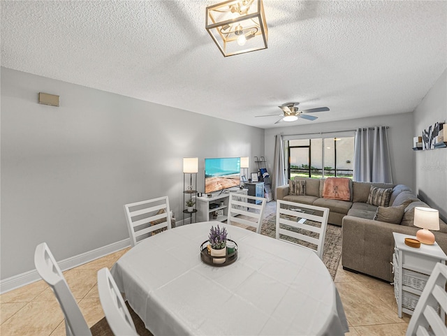 tiled dining room with a textured ceiling and ceiling fan