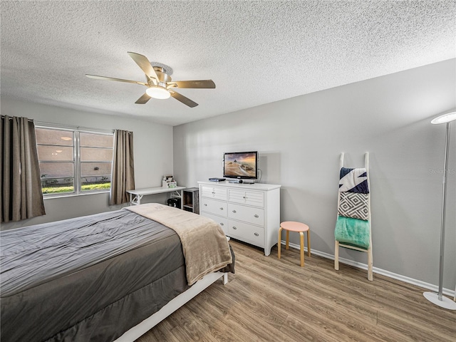 bedroom with ceiling fan, a textured ceiling, and light wood-type flooring