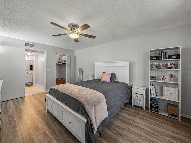 bedroom featuring dark hardwood / wood-style flooring, a textured ceiling, and ceiling fan