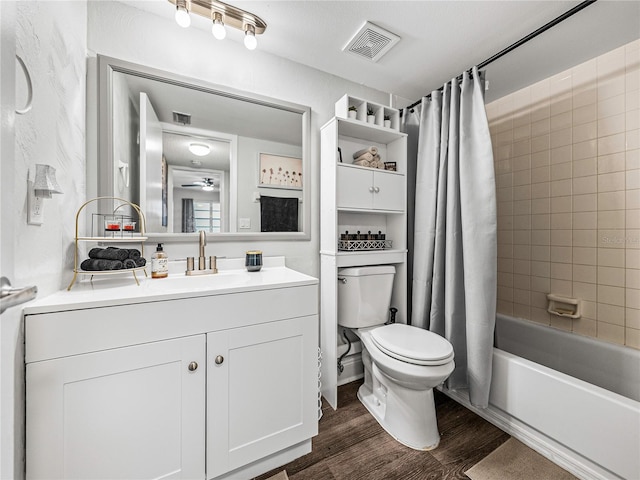 full bathroom with vanity, hardwood / wood-style flooring, toilet, shower / tub combo with curtain, and ceiling fan