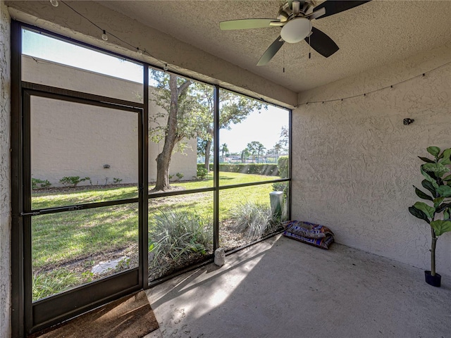 unfurnished sunroom featuring ceiling fan