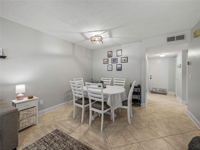 dining area featuring a textured ceiling and light tile patterned flooring