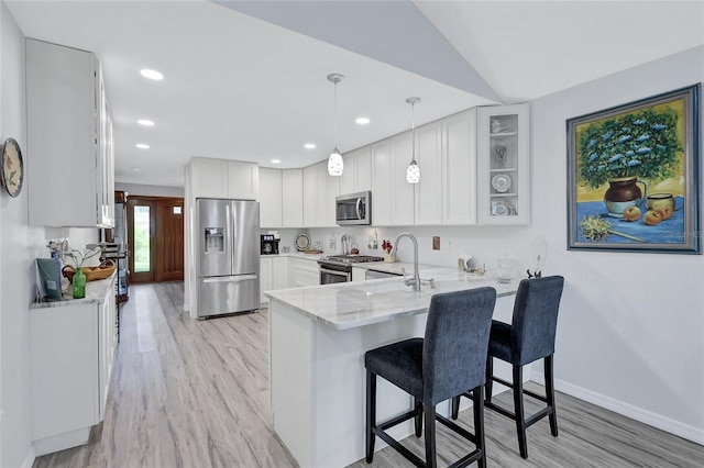 kitchen featuring white cabinetry, appliances with stainless steel finishes, sink, and hanging light fixtures