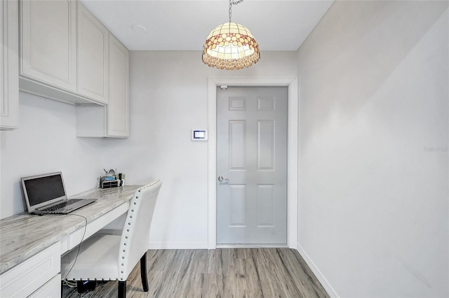 office space featuring built in desk and light hardwood / wood-style flooring