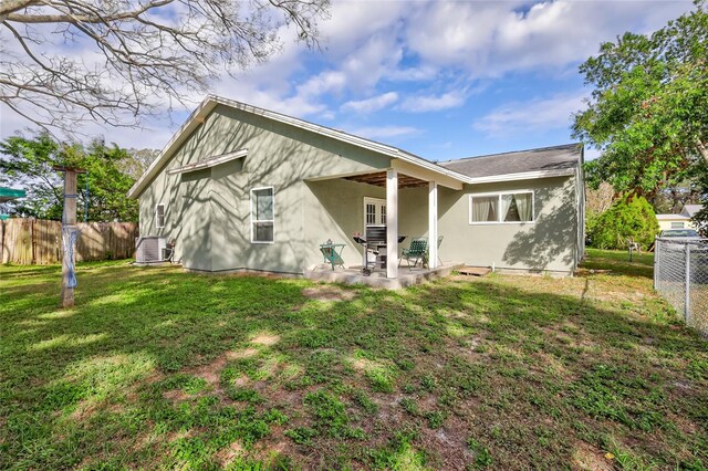 rear view of house with a patio and a lawn