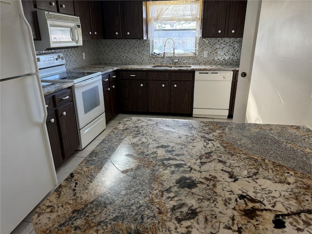 kitchen featuring tasteful backsplash, white appliances, sink, and dark brown cabinetry