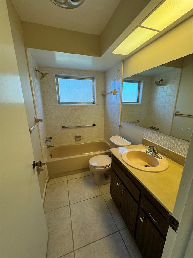 full bathroom with toilet, tiled shower / bath combo, vanity, and tile patterned flooring