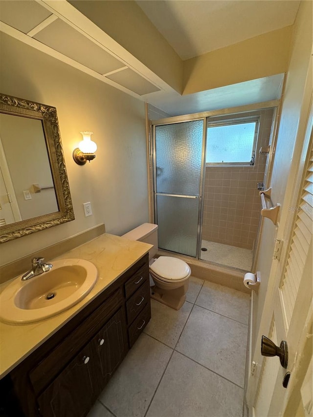 bathroom featuring toilet, an enclosed shower, vanity, and tile patterned floors