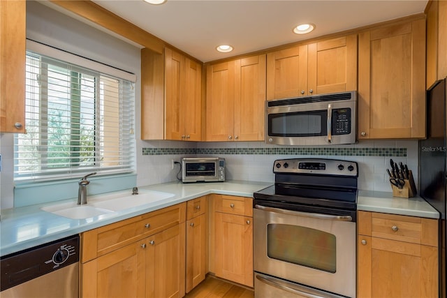 kitchen with stainless steel appliances, decorative backsplash, and sink