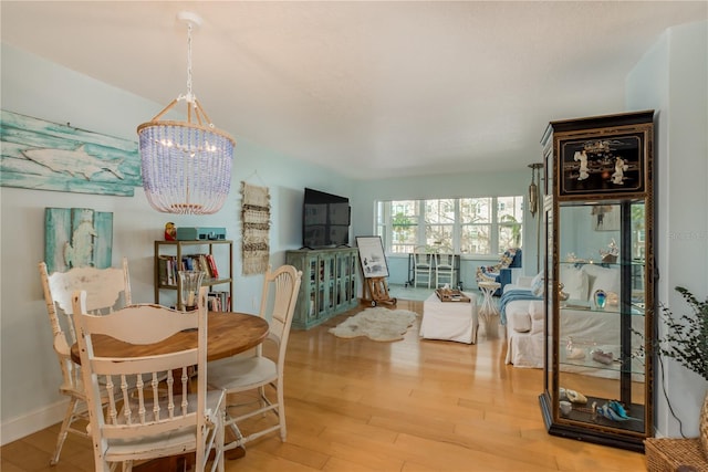 dining space featuring hardwood / wood-style flooring and a chandelier