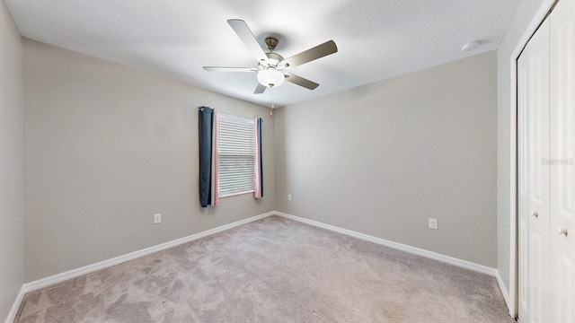 carpeted empty room with a textured ceiling and ceiling fan