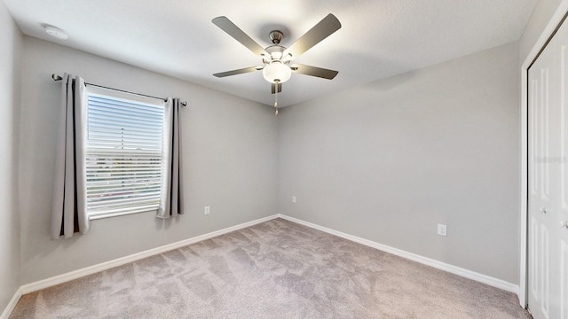 unfurnished room featuring light carpet and ceiling fan