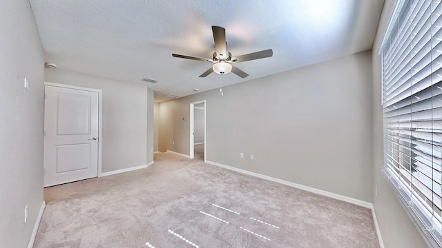 carpeted spare room featuring a textured ceiling and ceiling fan