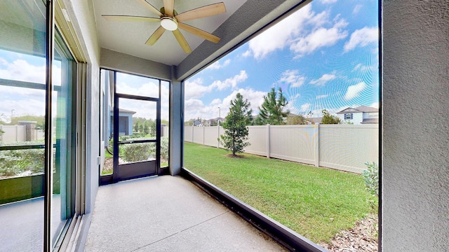 unfurnished sunroom with ceiling fan