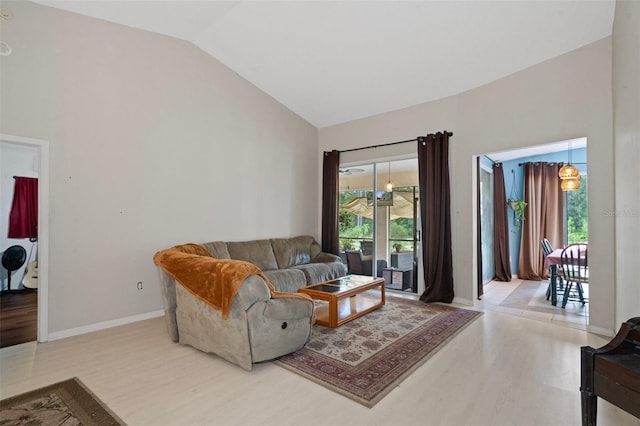 living room featuring light wood-type flooring, vaulted ceiling, and plenty of natural light