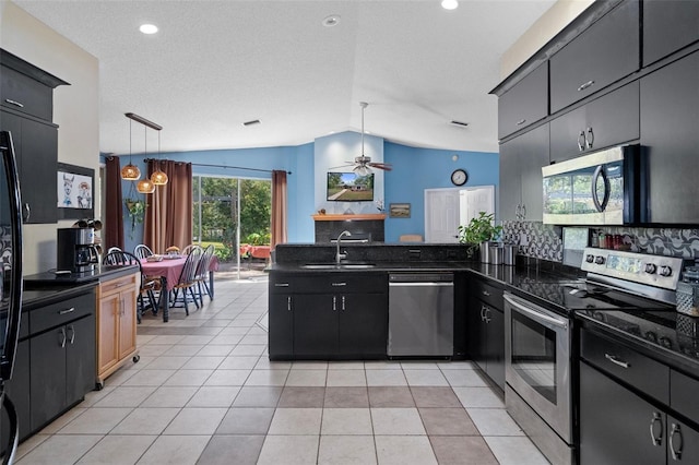 kitchen featuring stainless steel appliances, sink, ceiling fan, decorative light fixtures, and lofted ceiling