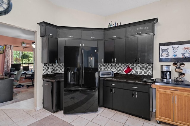 kitchen with dark stone countertops, decorative backsplash, black fridge with ice dispenser, and light tile patterned floors