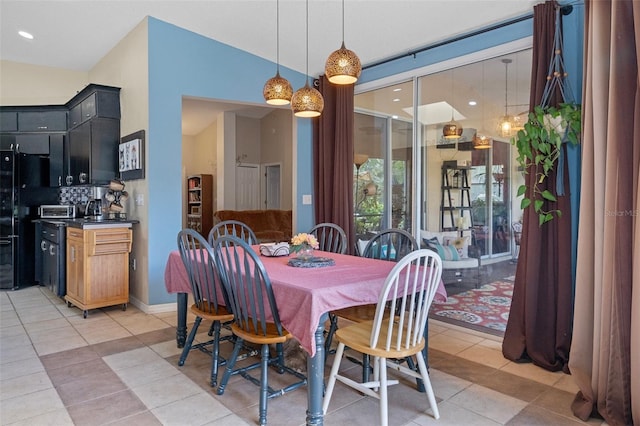 tiled dining space featuring vaulted ceiling